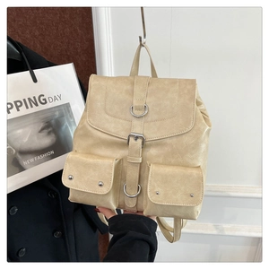 Détail du sac à dos en similicuir beige avec texture vintage et boucles argentées