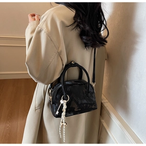 Detailed back view of a chic black textured crossbody bag styled with a fashion model