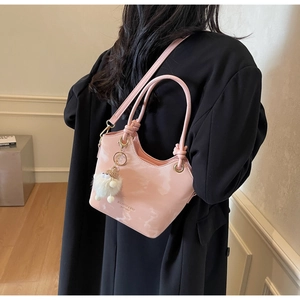 Detail of pink marble pattern bucket bag with plush charm and polished surface finish