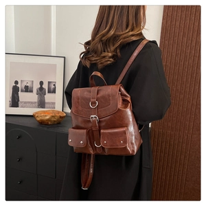 Sac à dos vintage en cuir marron avec deux poches frontales et détails de boucles en métal