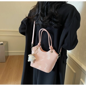 Detail of pink marble pattern handbag with dual handles and plush sheep charm