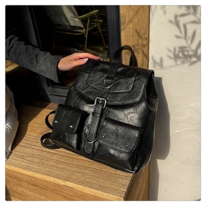Gros plan sur la texture du sac à dos en cuir noir avec boucle à anneau argenté