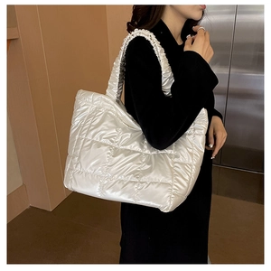 Silver quilted puffer tote bag with ruched straps shown on model for size and fit