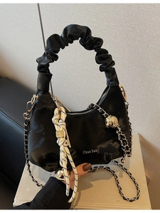 Minimalist black pleated cloud handbag with metallic chain and woven ornament