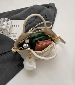 Draufsicht auf beige Beuteltasche zeigt geräumigen Innenraum mit Handy, Geldbörse und Kosmetik