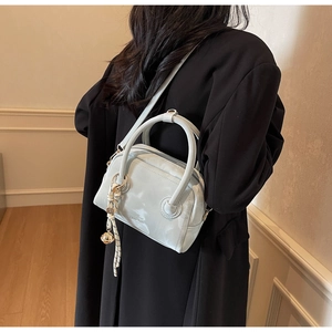Glossy light blue mini crossbody bag with woven strap and gold charm detail