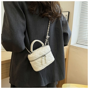 Détail du mini sac matelassé blanc avec chaîne en métal tressé cuir et double fermeture