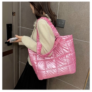 Detail of pink quilted puffer tote bag with glossy finish and ruched comfort handles