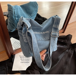 Dettaglio della tracolla in denim regolabile con fibbia argento su borsa blu