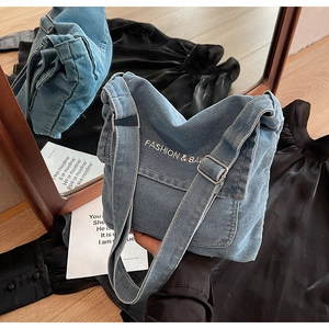 Dettaglio della borsa a tracolla in denim blu con ricami fashion e fibbie regolabili