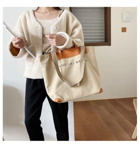 Close-up of large canvas tote bag with brown leather handles for casual daily use