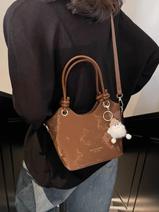 Brown oil wax leather tote bag with plush charm and adjustable shoulder strap for women