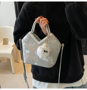 Détail du sac seau métallisé argenté avec ouverture en V et breloque monstre en peluche