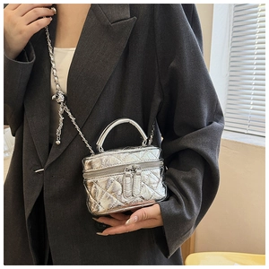 Détails du mini sac matelassé argenté avec bandoulière sur blazer gris pour l'échelle