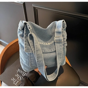 Dettaglio della borsa a tracolla in denim blu con ricamo e ampia tracolla regolabile