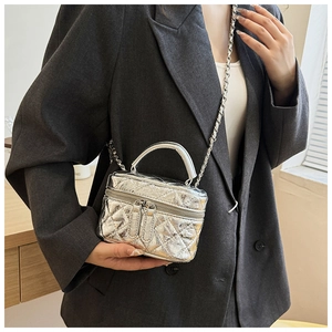 Détail du mini sac seau matelassé argenté avec bandoulière chaîne et fini métallisé