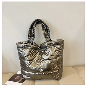 Detailed shot of quilted metallic silver tote bag with textured ruffles on the handles