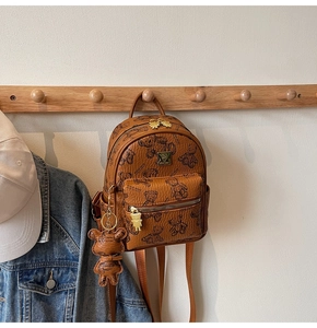Detailopname van bruine mini-rugzak met teddybeerprints en metalen beer-ritssluiting