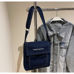 Dettaglio della borsa a tracolla in denim blu navy con ricamo e fibbia in metallo regolabile