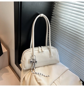 Détail du sac Boston blanc cassé minimaliste avec nœud argenté et décor de corde tressée