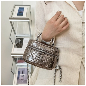 Détails du mini sac argenté matelassé avec poignée métallique et bandoulière à boules