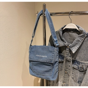 Dettaglio della borsa a tracolla in denim blu con ricamo FASHION & BAGS e tracolla regolabile