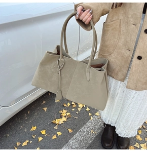 Borsa tote beige in pelle scamosciata con manici lunghi in un ambiente autunnale