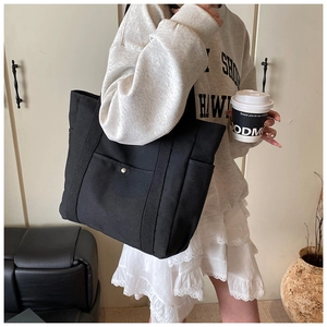 Detailansicht der minimalistischen schwarzen Canvas-Tragetasche mit Taschen und Druckknopf