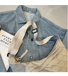 Flat lay of a beige quilted hobo bag with a wide adjustable shoulder strap and zipper