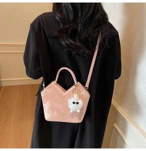 Sac seau rose avec ouverture en V élégante et pendentif en peluche blanche