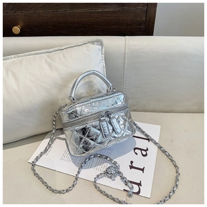 Détail du sac matelassé argenté avec boucle à bille dorée ajustable sur la chaîne