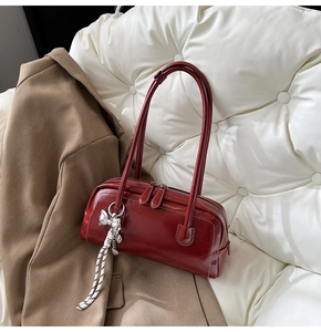 Détails du sac Boston bordeaux en similicuir avec pendentif nœud argenté et double zip