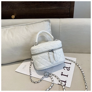 Vue détaillée du mini sac vanity blanc matelassé avec chaîne argentée et boule métallique