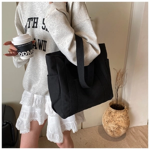 Minimalistische schwarze Canvas-Einkaufstasche mit breitem Schultergurt im Lifestyle-Stil