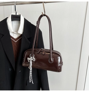 Détail du sac Boston marron foncé avec surpiqûres blanches et foulard noeud