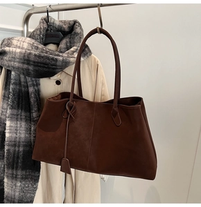 Detail of deep brown suede tote bag texture with minimalist straps in a chic style