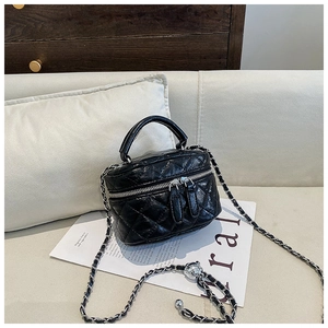 Vue détaillée d'un mini sac matelassé noir avec bandoulière chaîne argentée et double zip