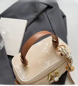 Détail du sac boîte motif marbre avec poignée en cuir marron et anneau doré