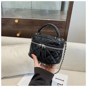 Détail du mini sac seau matelassé noir avec bandoulière chaîne et poignée