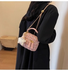Pink tweed crossbody bag with golden chain and plush ghost charm shown on model