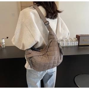 Detail of quilted nylon crescent bag in brown with adjustable wide shoulder strap