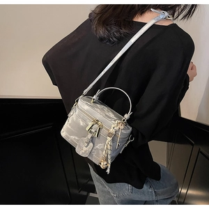 Détail du sac boîte gris texturé avec poignée rigide et bandoulière réglable