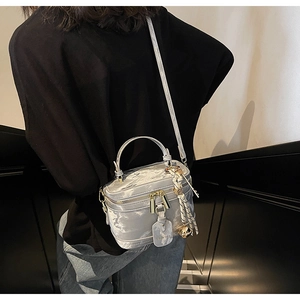 Détail du sac boîte à texture marbre argenté avec finitions dorées et charm cloche