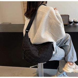 Close-up of black quilted hobo bag with adjustable strap and diamond stitch texture
