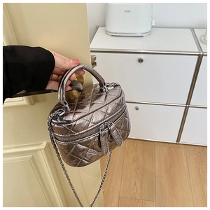 Détail du mini sac vanité en cuir matelassé argenté avec chaîne et poignée incurvée