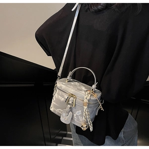 Détail du sac boîte gris marbré avec ferrures dorées et accessoire foulard rayé chic