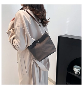 Vue détaillée de la texture tissée marron foncé et de la boucle argentée du sac à main