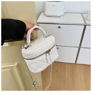 Gros plan sur un mini sac à main blanc matelassé avec bandoulière chaîne argentée