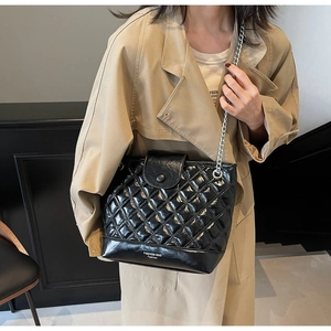 Detail of glossy quilted bucket bag with silver chain strap and fashion logo print
