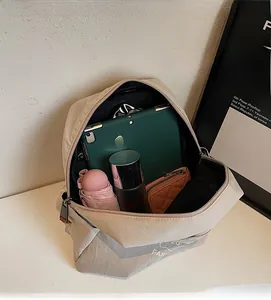 Spacious interior of beige nylon backpack showing tablet and daily essentials